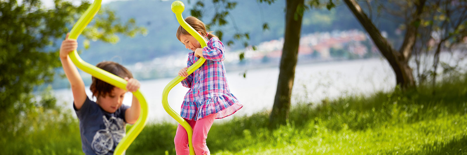 Dans une aire de jeux, des enfants tournent sur de petites toupies.